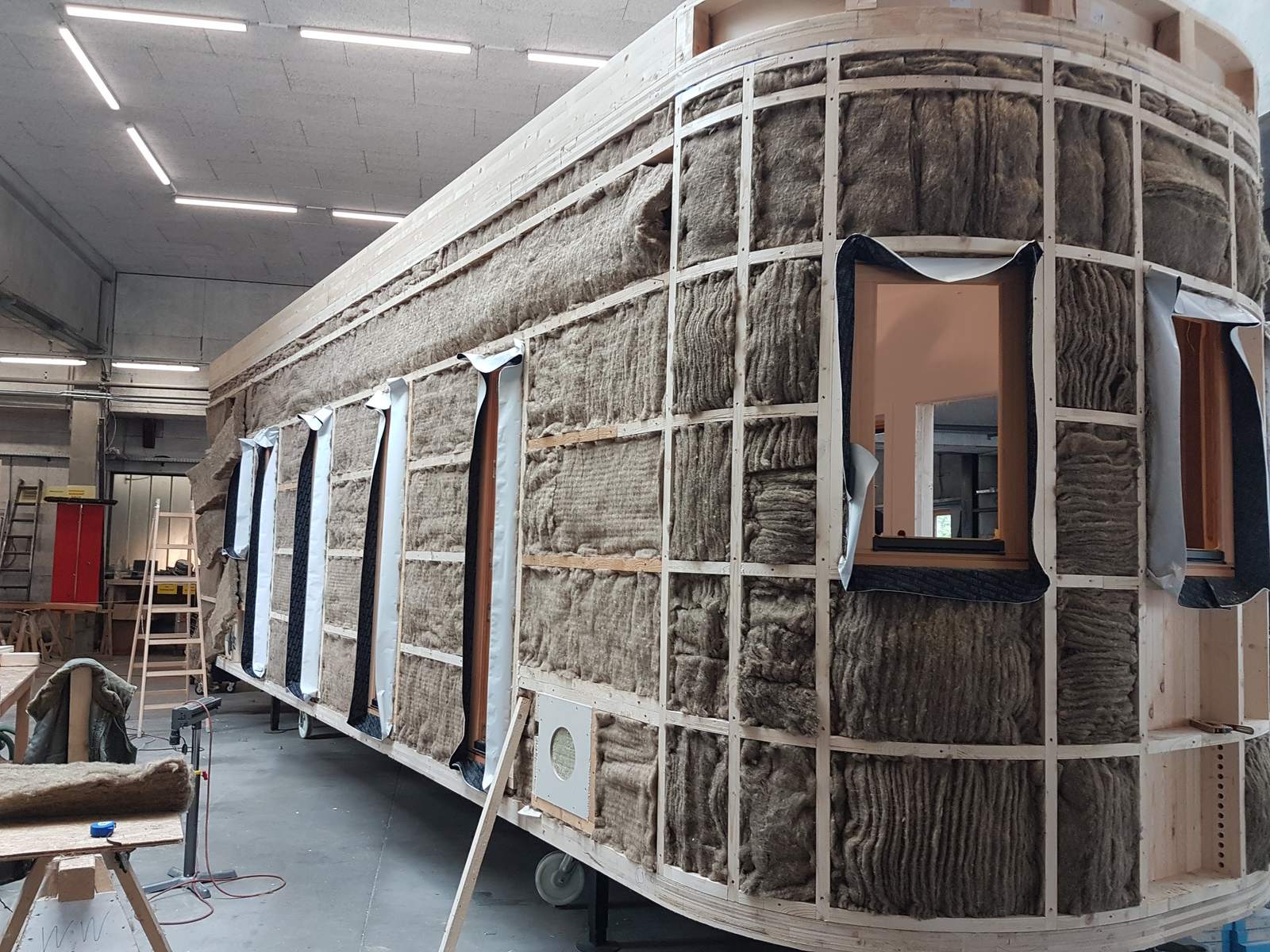 Der Rohbau des Wagons von außen, zwischen den Ständern liegt die Dämmung offen.