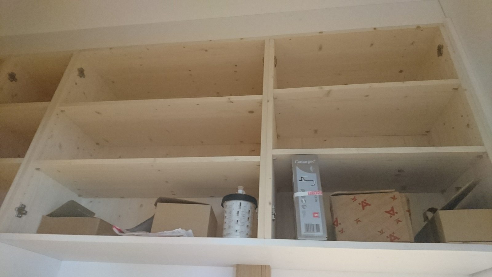 Eingebaute Regalfächer aus hellem Holz, noch ohne Inhalt.