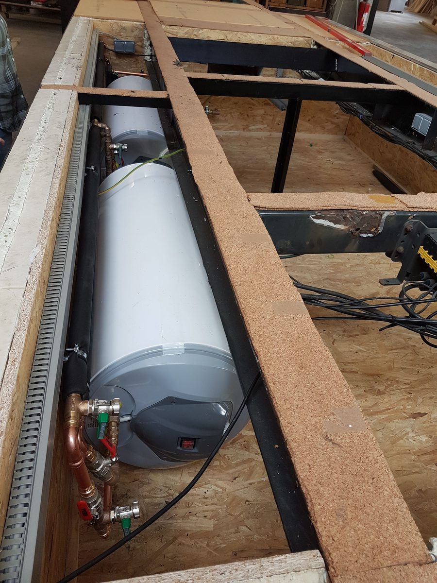 Ein liegender Wassertank ist unter dem Bodenaufbau zwischen die Träger gesetzt.