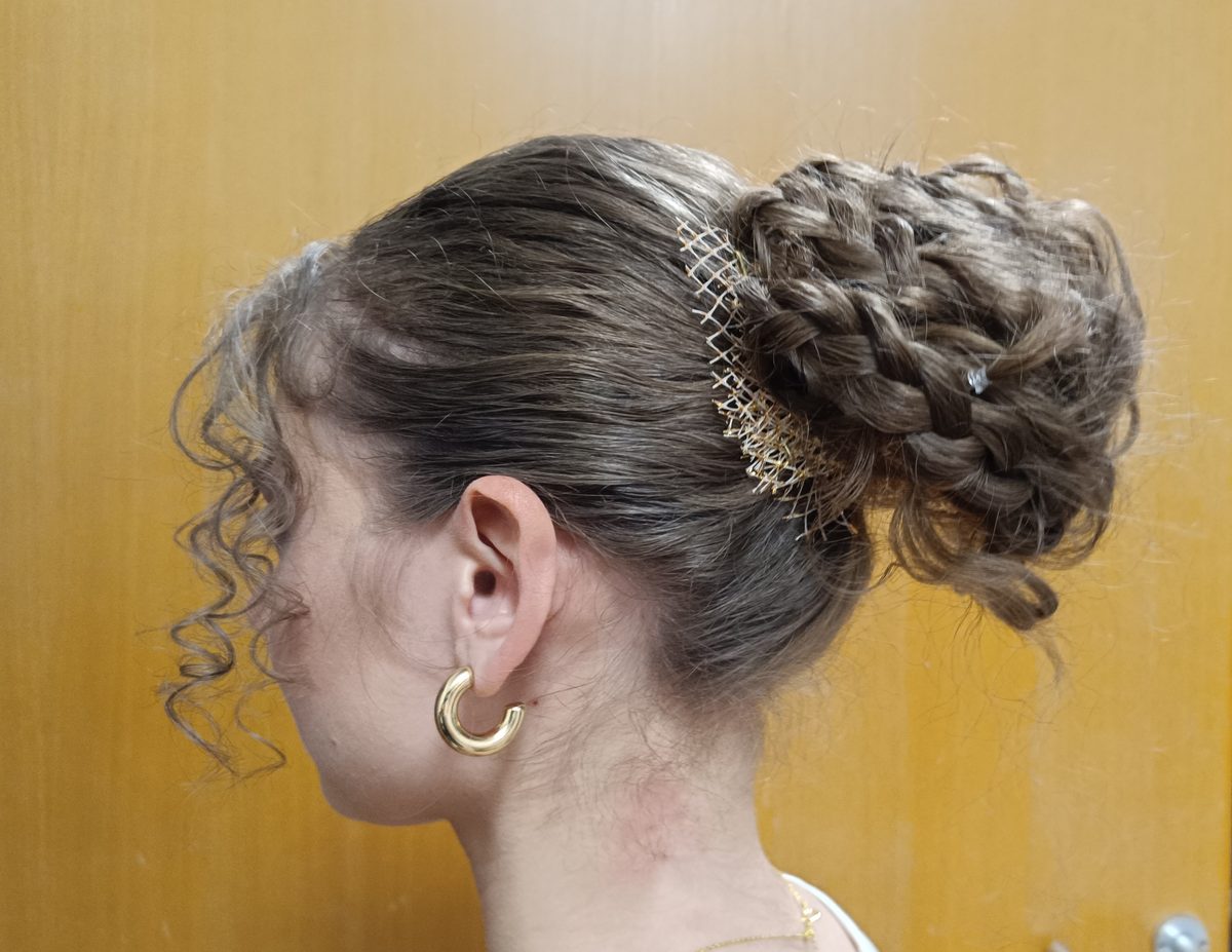 Ein geflochtener Haarknoten am Hinterkopf, durchzogen mit einer silbernen Haarkette.
