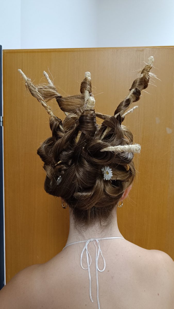 Dieselbe Hochsteckfrisur von hinten, die Schlaufen stehen nach oben ab.