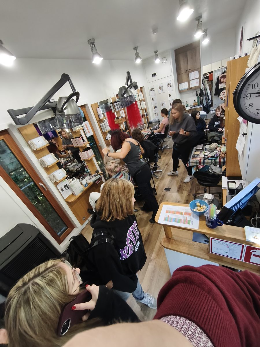 Mehrere Modelle werden gleichzeitig frisiert und geschminkt, der Salon ist voll.
