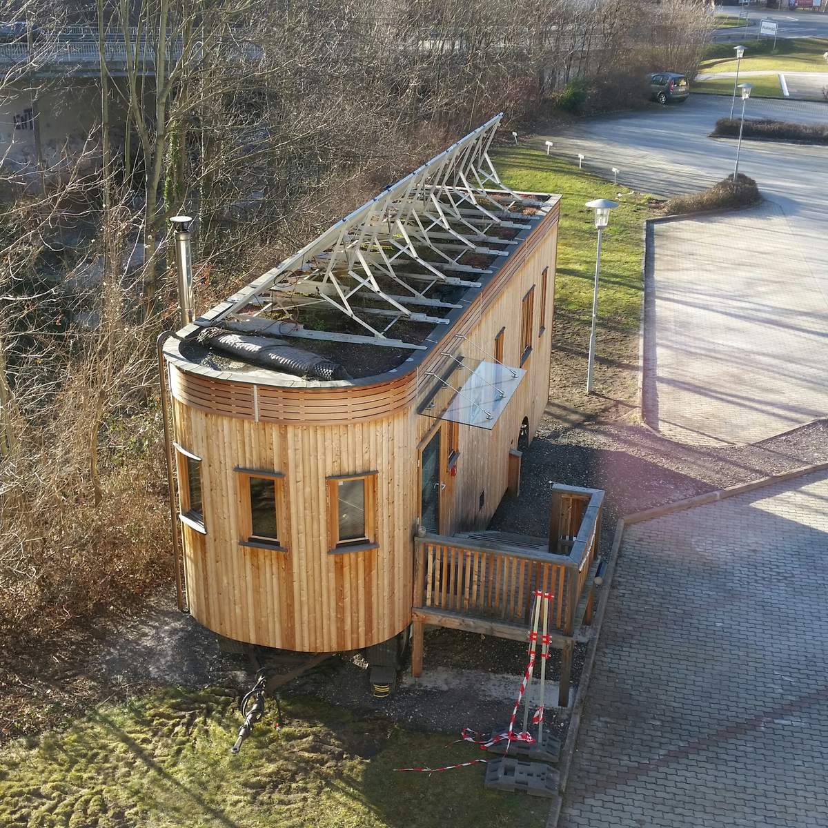 Der Wagon von oben an seinem Platz, davor eine Holzterrasse mit Stiege.