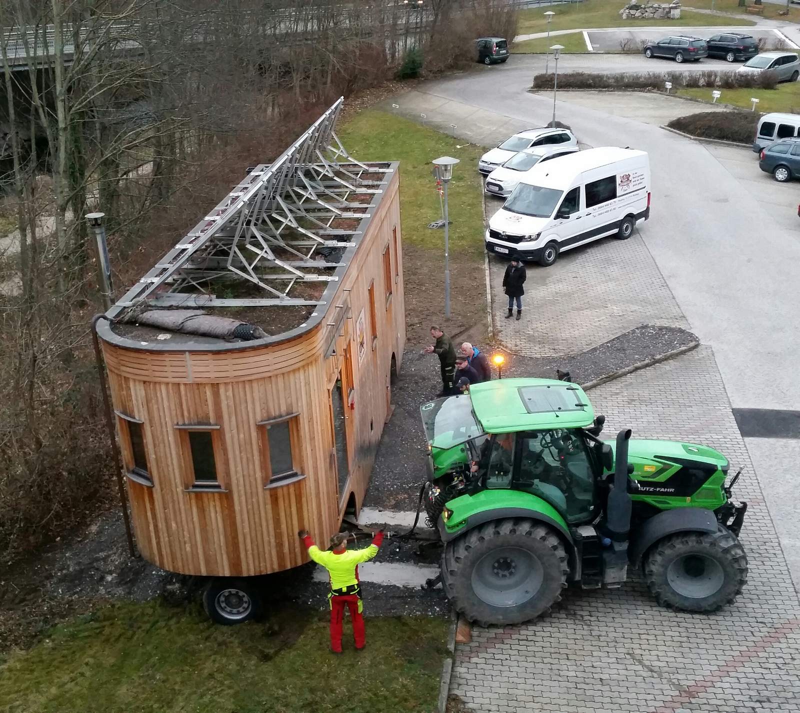 Mehrere Personen weisen den Traktorfahrer ein, während der Wagon zentimeterweise rangiert wird.